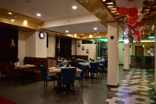 a dining room with tables and blue chairs in a restaurant at HOTEL MONTANA VYOO in Namchi
