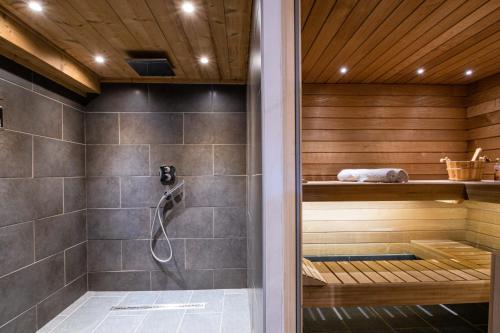 una sauna con ducha y una puerta de cristal en Chalet Le R'Posiao, en Morzine