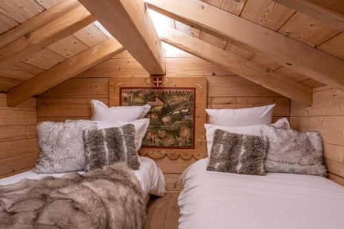 a bedroom with two beds in a log cabin at Chalet Le R'Posiao in Morzine