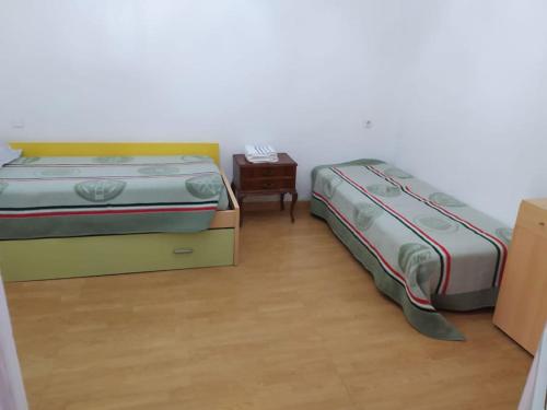 a bedroom with two beds and a night stand at Amplio piso en centro con balcón in Cuenca