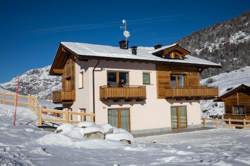 a house with snow in front of it at Pianeta Oro Chalet Allegra in Livigno