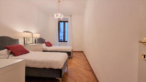 Habitación pequeña con 2 camas y sofá en Palazzo Crispi - Boutique Apartment, en Trieste
