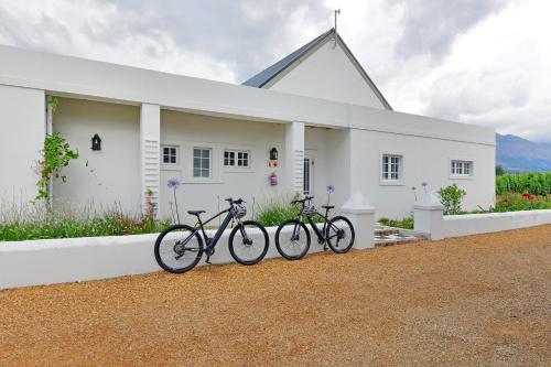 three bikes parked in front of a white house at Fransvliet Guest House in Franschhoek
