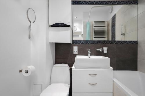bagno con servizi igienici, lavandino e specchio di Black&White a Cracovia