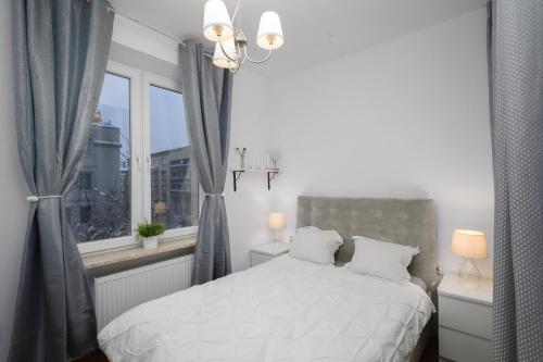 una camera con un letto bianco e una finestra di Black&White a Cracovia