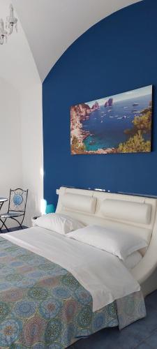 een slaapkamer met een groot bed met een blauwe muur bij B&B SOGNANDO VIETRI in Aversa