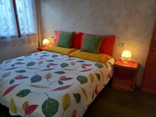 ein Bett in einem Schlafzimmer mit zwei Lampen an Tischen in der Unterkunft Appartamento Marco in Bormio