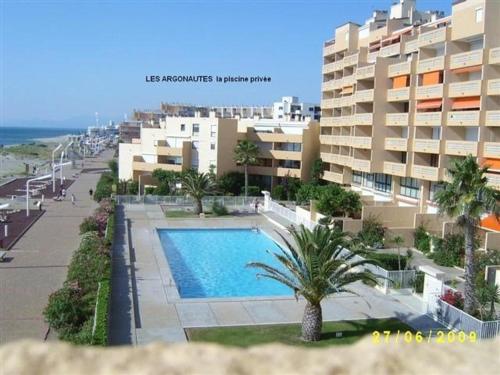 - une vue sur un bâtiment et une piscine dans l'établissement Grand T3 à 100m des commerces, plage et piscine, 6 couchages, parking facile - FR-1-81-507, au Barcarès
