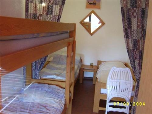 - une petite chambre avec 2 lits superposés et une chaise dans l'établissement Grand T3 à 100m des commerces, plage et piscine, 6 couchages, parking facile - FR-1-81-507, au Barcarès