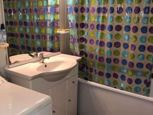 une salle de bain avec un lavabo et un rideau de douche dans l'établissement Grand T3 à 100m des commerces, plage et piscine, 6 couchages, parking facile - FR-1-81-507, au Barcarès