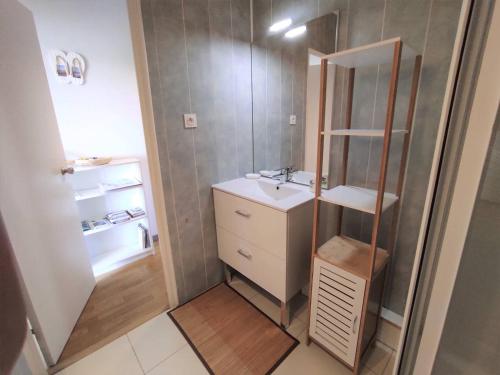 une petite salle de bain avec un lavabo et un miroir dans l'établissement Appartement rénové, calme 300m plage, avec parking et balcon – Beg Meil, Fouesnant - FR-1-481-55, à Fouesnant