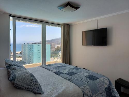 a bedroom with a bed and a large window at Departamento Papudo Laguna in Papudo