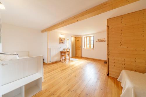 1 dormitorio con paredes blancas y suelo de madera en Le Fournia, en Grandrif