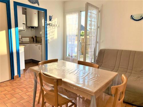 une table à manger et des chaises dans un salon dans l'établissement Charmante maison 2 pièces, 4 pers, plage à pied, quartier calme, jardin, Wi-Fi, animaux ok, parking - FR-1-478-171, à Quiberon