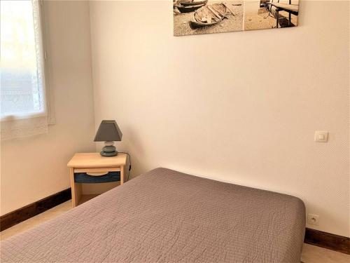 une chambre avec un lit et une table avec une lampe dans l'établissement Charmante maison 2 pièces, 4 pers, plage à pied, quartier calme, jardin, Wi-Fi, animaux ok, parking - FR-1-478-171, à Quiberon