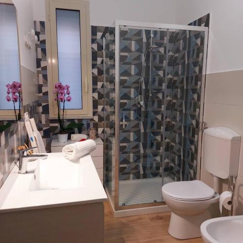 a bathroom with a shower and a toilet and a sink at Blue Sicily Apartment in Roccalumera
