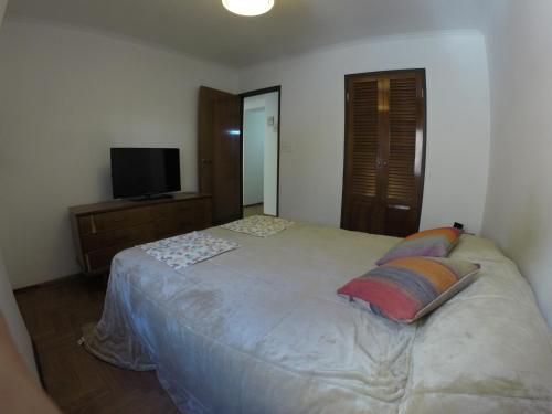 1 dormitorio con 1 cama blanca grande y 2 almohadas en 9 de Julio Confort - Bienes Reales en Córdoba