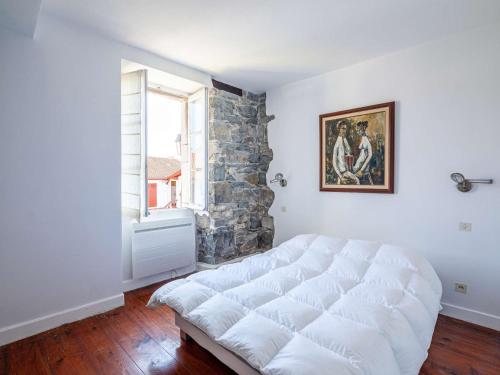 - une chambre avec un grand lit blanc devant une fenêtre dans l'établissement Bel appartement avec balcon à 5 min de la plage et proche du centre, classé 2 étoiles - FR-1-2-385, à Hendaye
