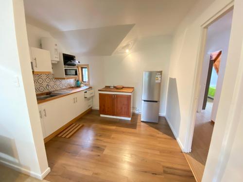 a kitchen with white appliances and a wooden floor at Dpto tipo cabaña en Pucón in Pucón