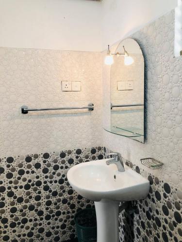 a bathroom with a sink and a mirror at Nilan Villa in Koggala