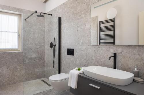 uma casa de banho com um lavatório, um WC e um chuveiro em Villa Estelle by ILC (Istria Luxury Collection) em Brtonigla