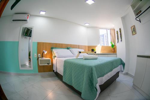1 dormitorio con 1 cama grande con manta verde en Studio Encantador - Garagem - Piscina na Cobertura, en João Pessoa