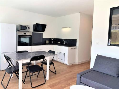une cuisine et une salle à manger avec une table et des chaises dans l'établissement Quiberon, appart 2 pièces rénové, à 2 pas de la plage, loggia sud, garage, classé 2*, pour 3 pers. - FR-1-478-182, à Quiberon