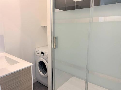 une buanderie avec un lave-linge et un lave-linge/sèche-linge dans l'établissement Quiberon, appart 2 pièces rénové, à 2 pas de la plage, loggia sud, garage, classé 2*, pour 3 pers. - FR-1-478-182, à Quiberon