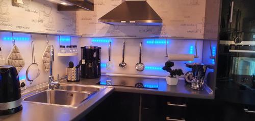 a kitchen with a sink and blue lights on the wall at Ferienwohnungen Am Markt in Rüdesheim am Rhein