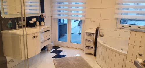 a white bathroom with a tub and a sink and a bath tub at Ferienwohnungen Am Markt in Rüdesheim am Rhein