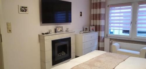 a bedroom with a fireplace with a television on the wall at Ferienwohnungen Am Markt in Rüdesheim am Rhein