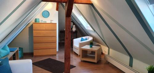 an attic room with a bed and a dresser at Ferienwohnungen Am Markt in Rüdesheim am Rhein