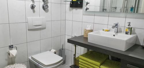 a white bathroom with a sink and a toilet at Ferienwohnungen Am Markt in Rüdesheim am Rhein