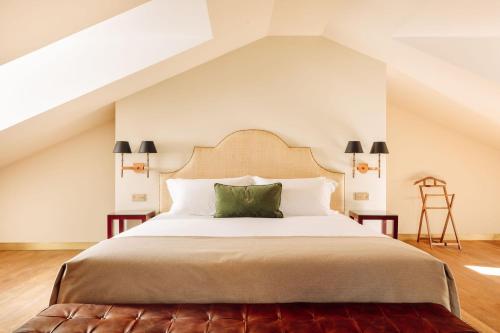um quarto com uma cama grande e uma almofada verde em Hotel das Amoreiras - Small Luxury Hotels of the World em Lisboa