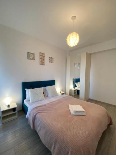 een slaapkamer met een groot bed met een blauw hoofdeinde bij Q Apartament Loft place near Palas Mall in Iaşi