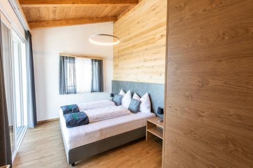um quarto com uma cama e uma parede de madeira em Seisen Almchalet em Murau
