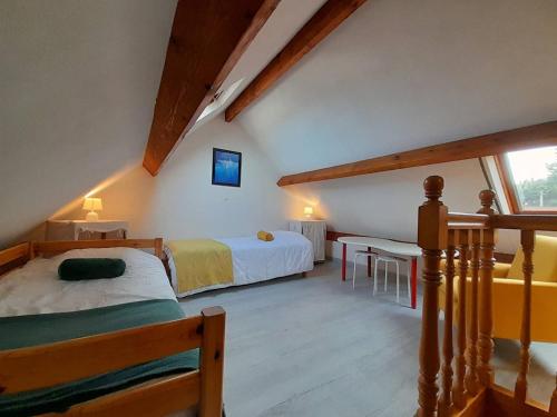 1 Schlafzimmer mit 2 Betten, einem Tisch und einem Fenster in der Unterkunft Appartement Saint-Philibert, 3 pièces, 4 personnes - FR-1-477-187 in Saint-Philibert