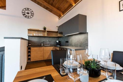 uma cozinha e sala de jantar com uma mesa com copos de vinho em Seisen Almchalet em Murau