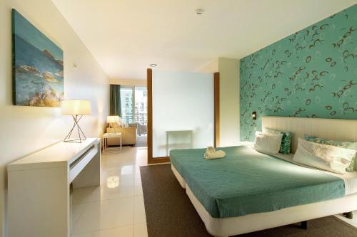 um quarto com uma cama com uma parede azul em Dfm Happy Days C - Funchal em Funchal