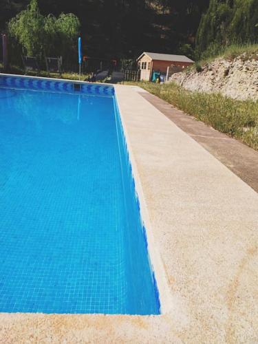 a large blue swimming pool next to a house at Apartment with pool in the mountains. in Alicante