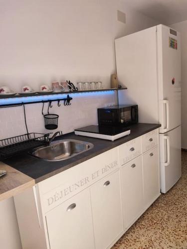 a kitchen with a sink and a white refrigerator at Apartment with pool in the mountains. in Alicante