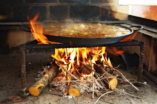 a large pot of food on top of a fire at Apartment with pool in the mountains. in Alicante