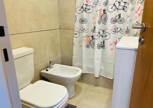 a bathroom with a toilet and a sink and a shower curtain at Monoambiente Calle 11 in La Plata