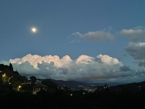 La Riviera Bed & Breakfast في رابالو: السماء غائمة مع القمر فوق المدينة
