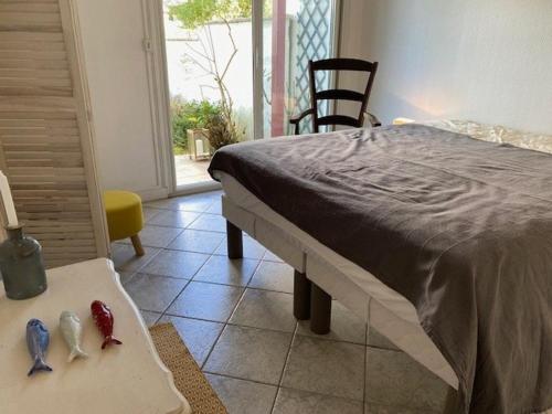 - une chambre avec un lit et deux figurines sur une table dans l'établissement Maison de vacances avec terrasse, jardin, garage, animaux acceptés à Royan - FR-1-494-116, à Royan