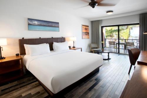 a bedroom with a large white bed and a desk at The Perry Hotel & Marina Key West in Key West