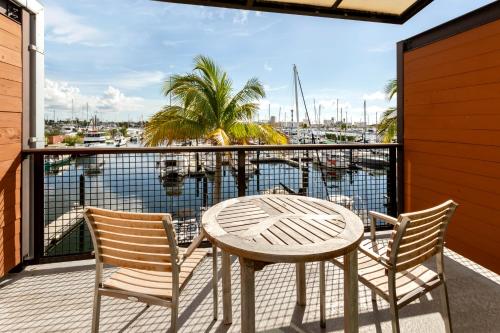 a table and chairs on a balcony with a view of a harbor at The Perry Hotel & Marina Key West in Key West
