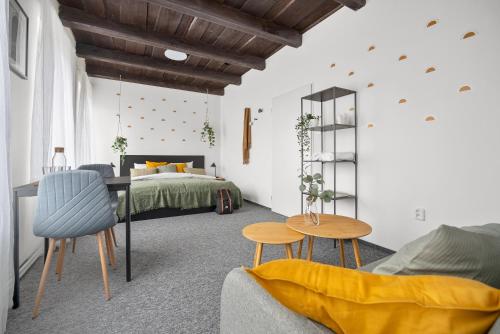 a bedroom with a bed and a table and chairs at Penzion Village Peace #29 by Goodnite cz - U Libušky in Brno