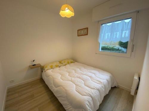 un lit dans une chambre avec une fenêtre dans l'établissement Appartement 3 pièces rénové avec piscine à Quiberon - Balcon, parking, proche plage - FR-1-478-207, à Quiberon