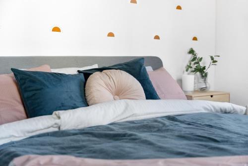 a bedroom with a bed with blue and pink pillows at Penzion Village Peace #29 by Goodnite cz - U Libušky in Brno